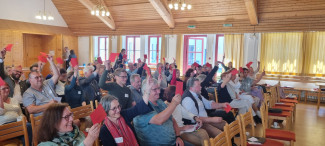 Abstimmung in der Frühjahrsynode: Die Mitglieder halten rote Stimmzettel hoch.